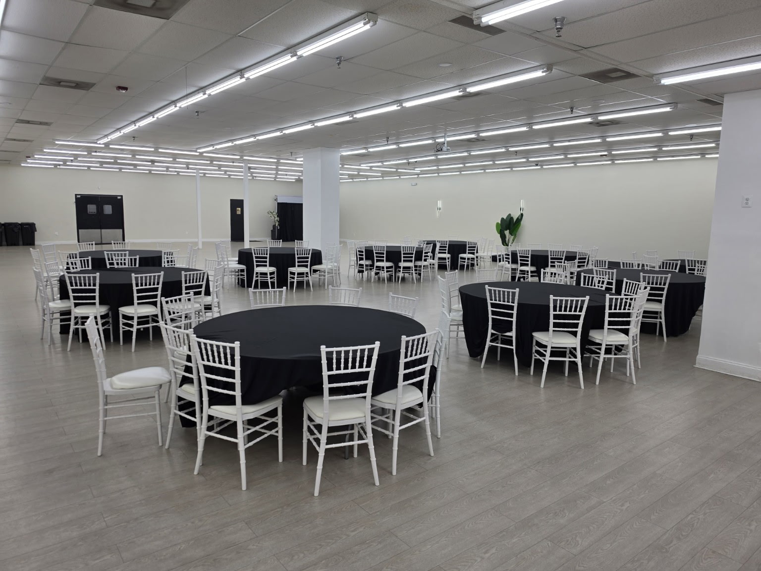 Elegant event hall set up for a celebration with floral centerpieces and warm lighting