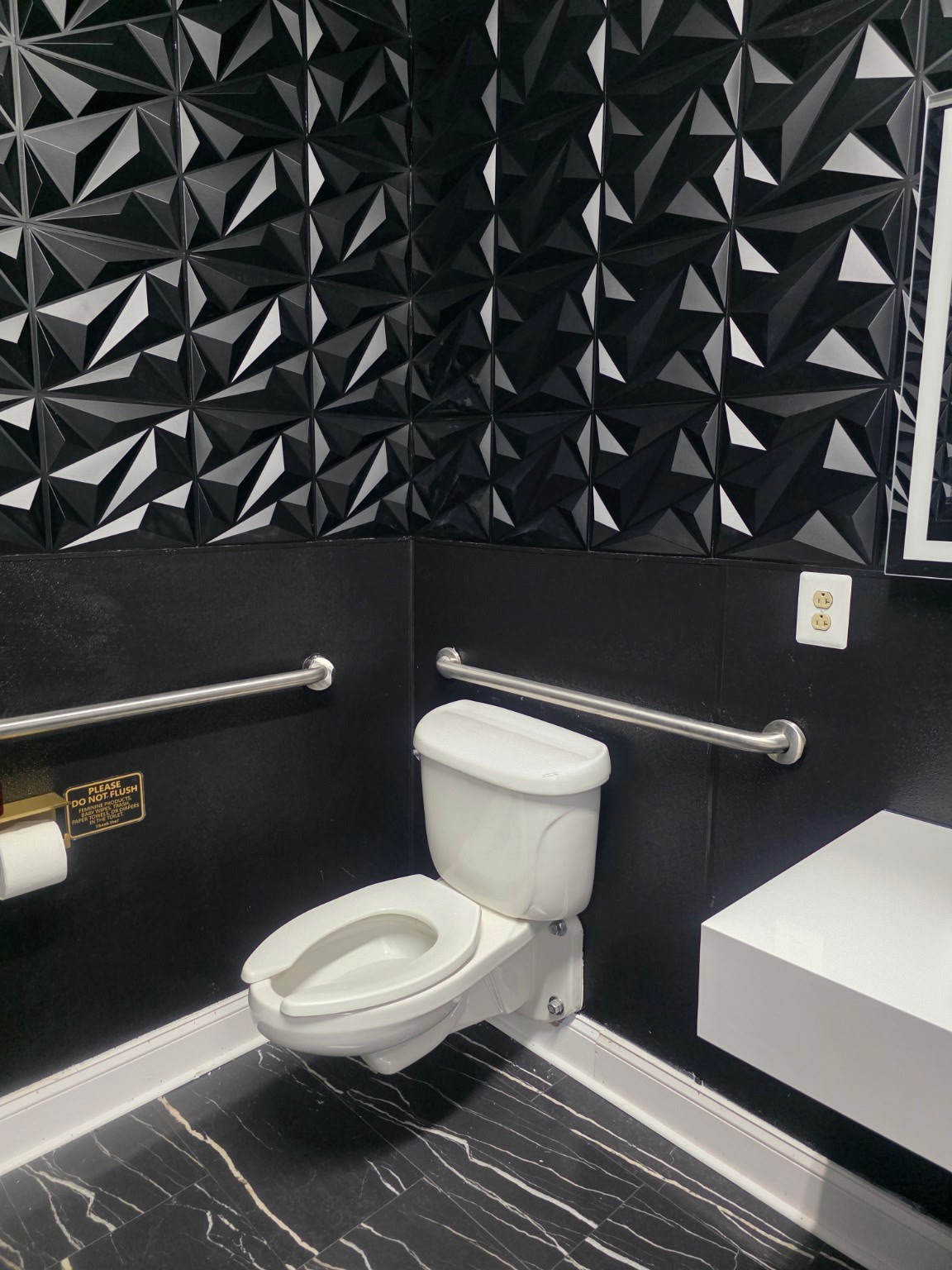 Celebration Hall restroom with black geometric tile and modern finishes